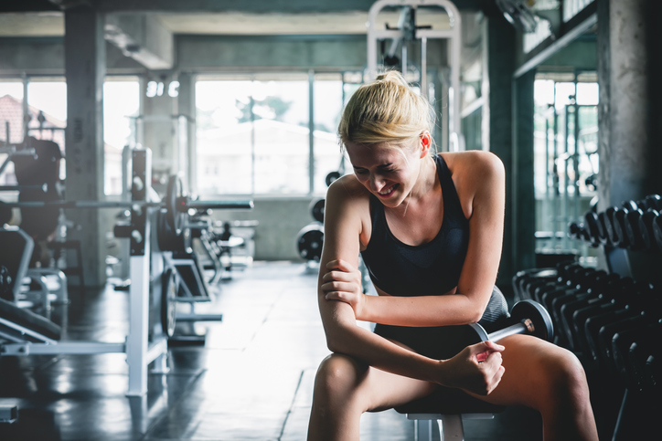 Shoulder pain Girl training in a gym with shoulder pain
