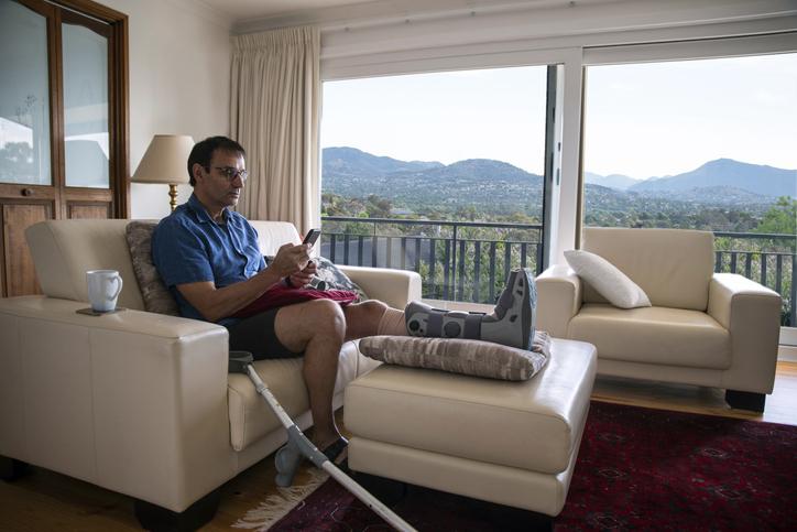 Man with broken leg rehabilitating at home