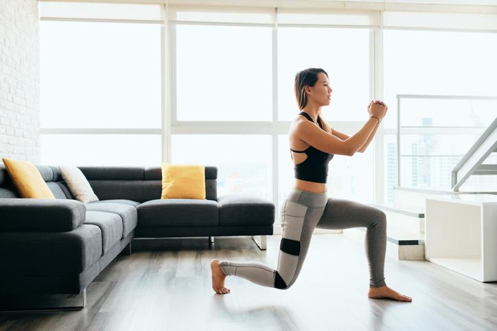 Female working out at home with lunges exercise 