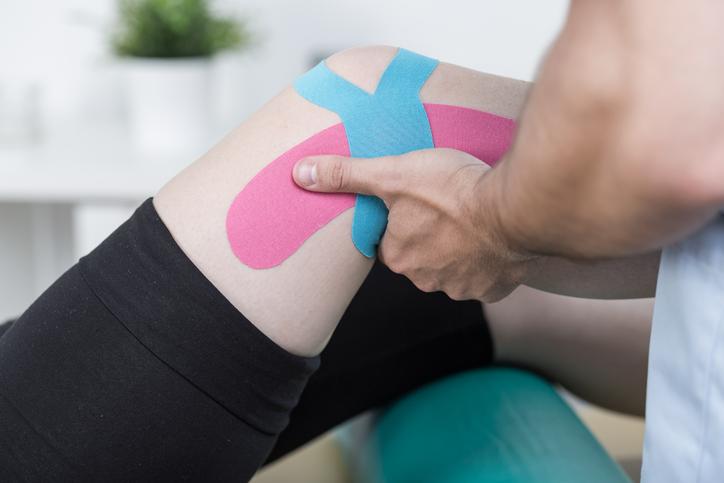Male patient having kinesiotape taping therapy for knee pain Male patient having kinesiotape taping therapy for knee pain
