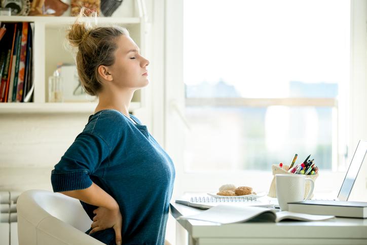 Postural back pain A girl working and sitting too long and getting back pain
