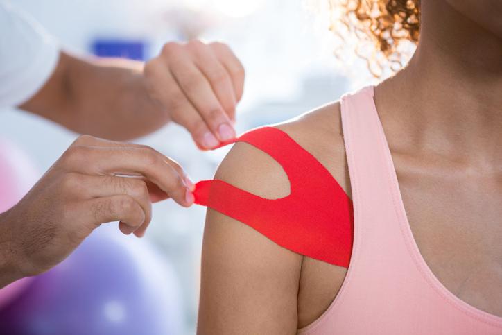 Female patient with kinesiotape taping therapy on shoulder Female patient with kinesiotape taping therapy on shoulder