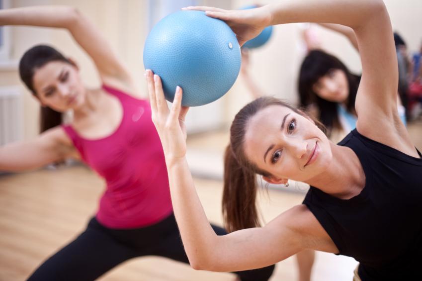 Group of people doing pilates with exercise ball