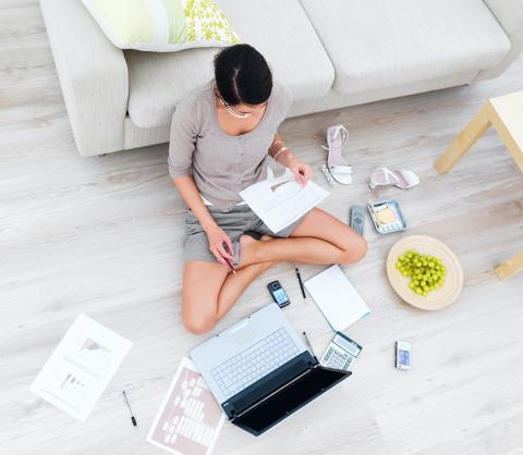 Female working cross-legs on the floor with laptop with poor posture